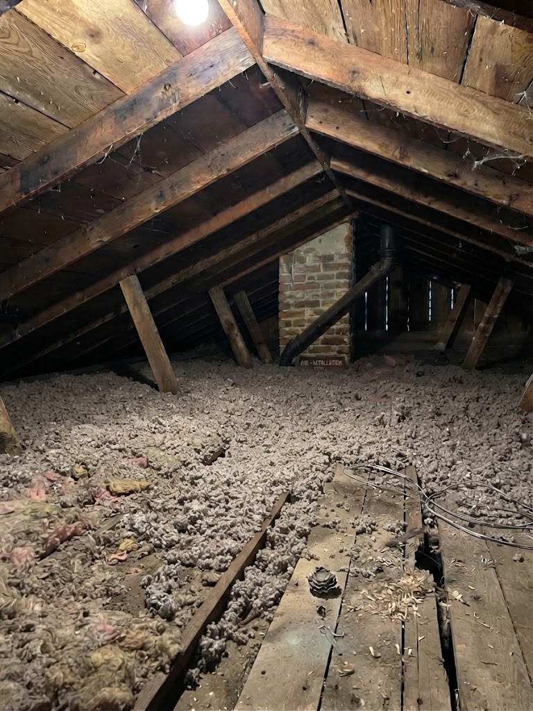 Denver attic before insulation work — sparse old insulation on bare boards
