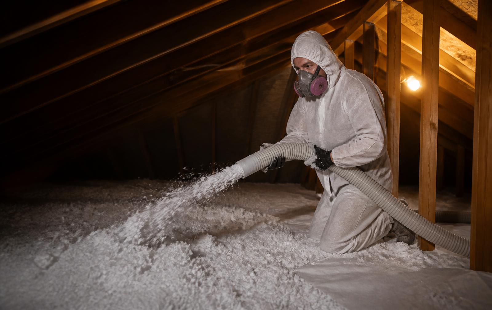 Technician installing blown-in insulation in an attic